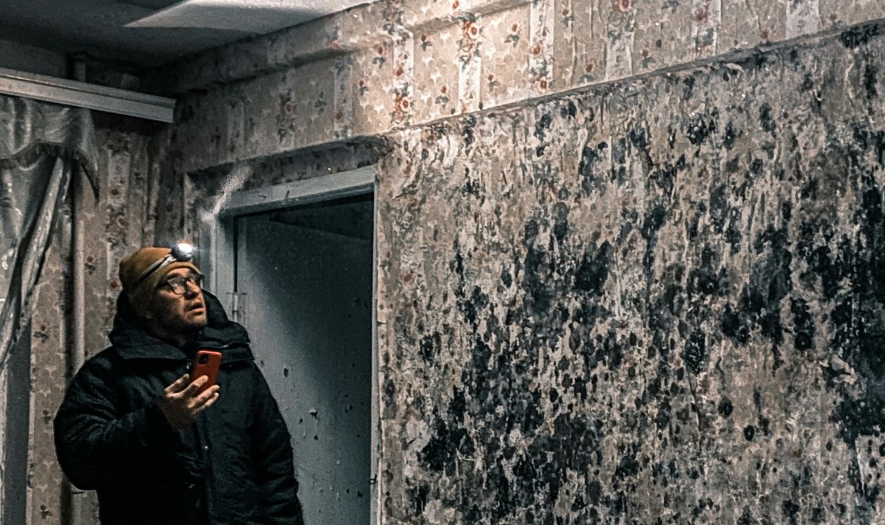 Man in Jacket Standing in Abandoned Room