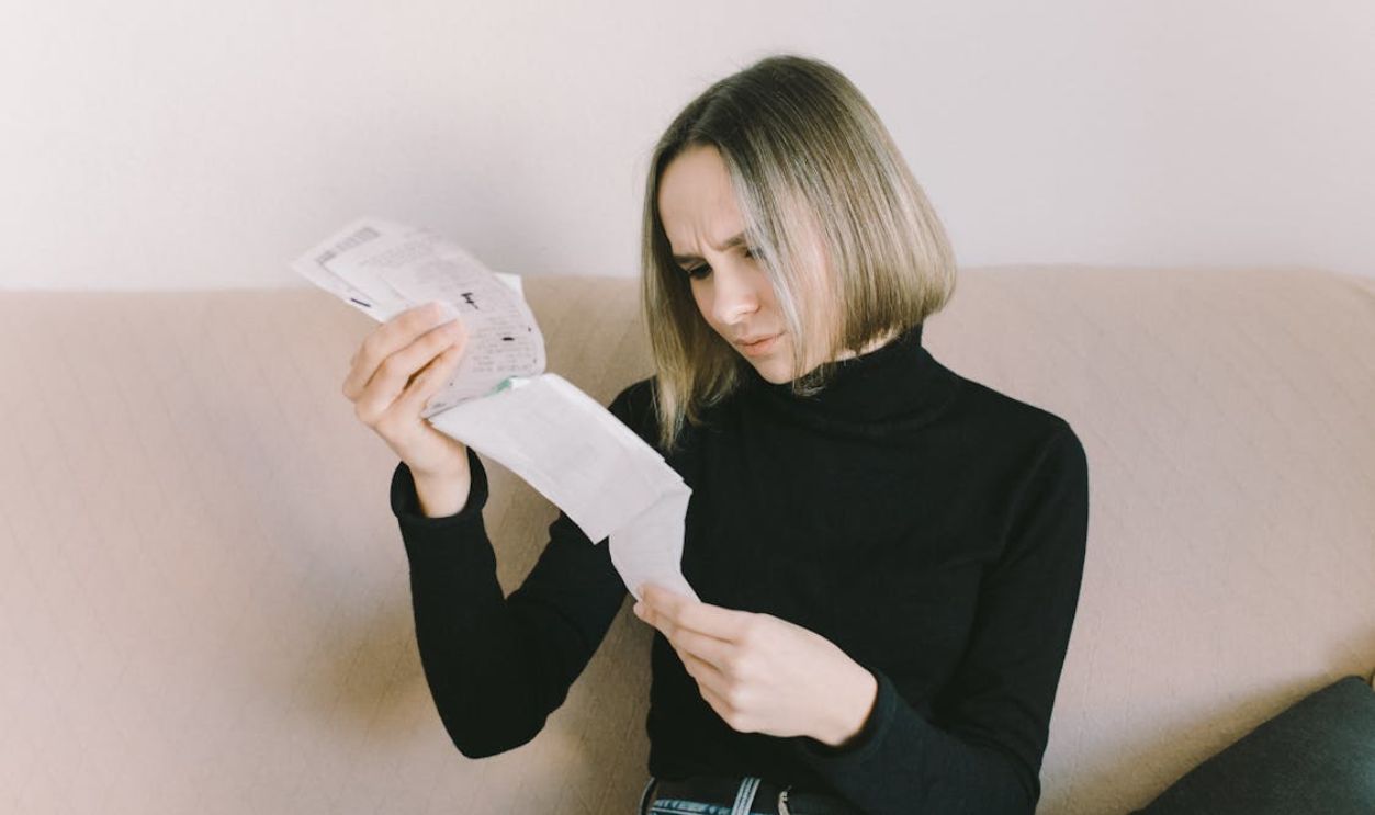A Woman in Black Long Sleeve Shirt Holding White Printer Paper