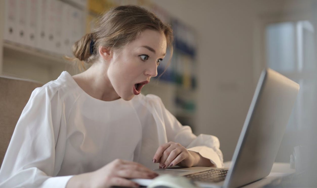 Woman in White Long Sleeve Shirt Using Silver Laptop Computer