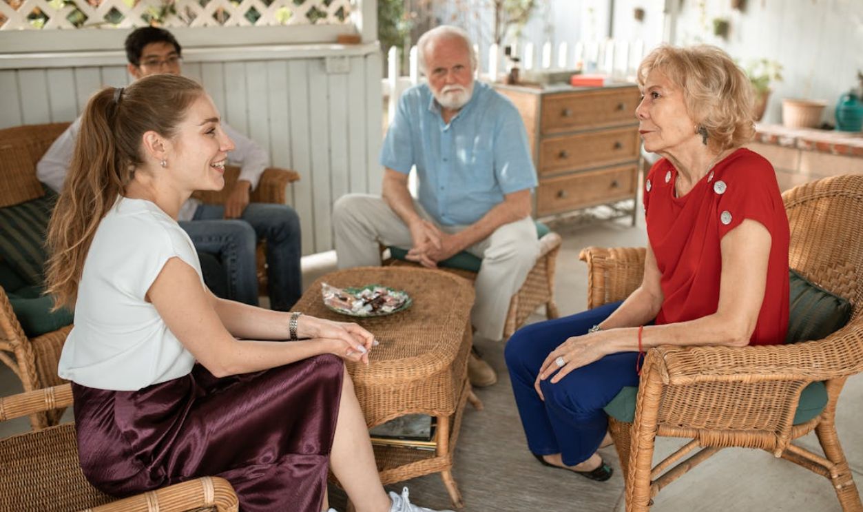 Woman in Blue Polo Shirt Sitting on Brown Woven Armchair