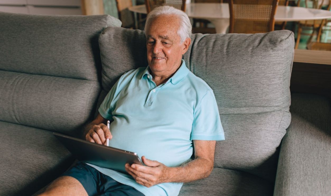 Senior Using Tablet While Sitting on Sofa