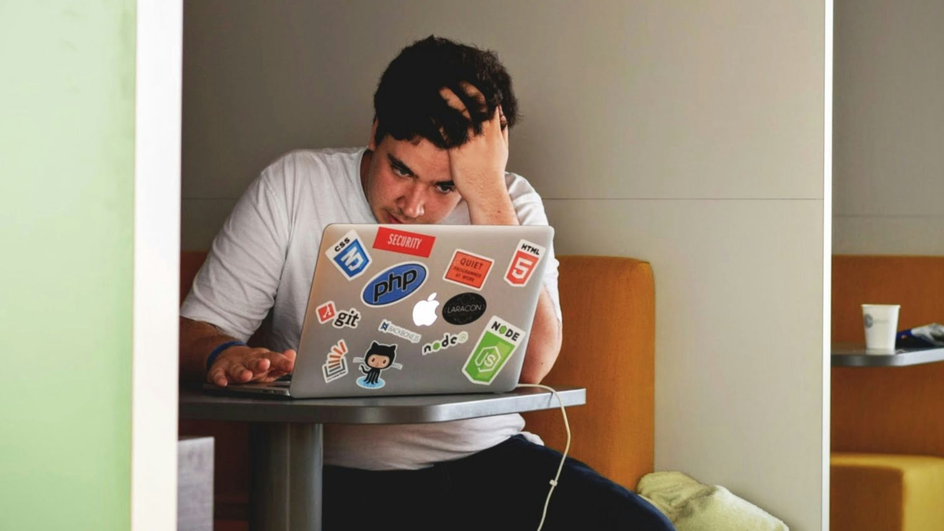 man wearing white top using MacBook