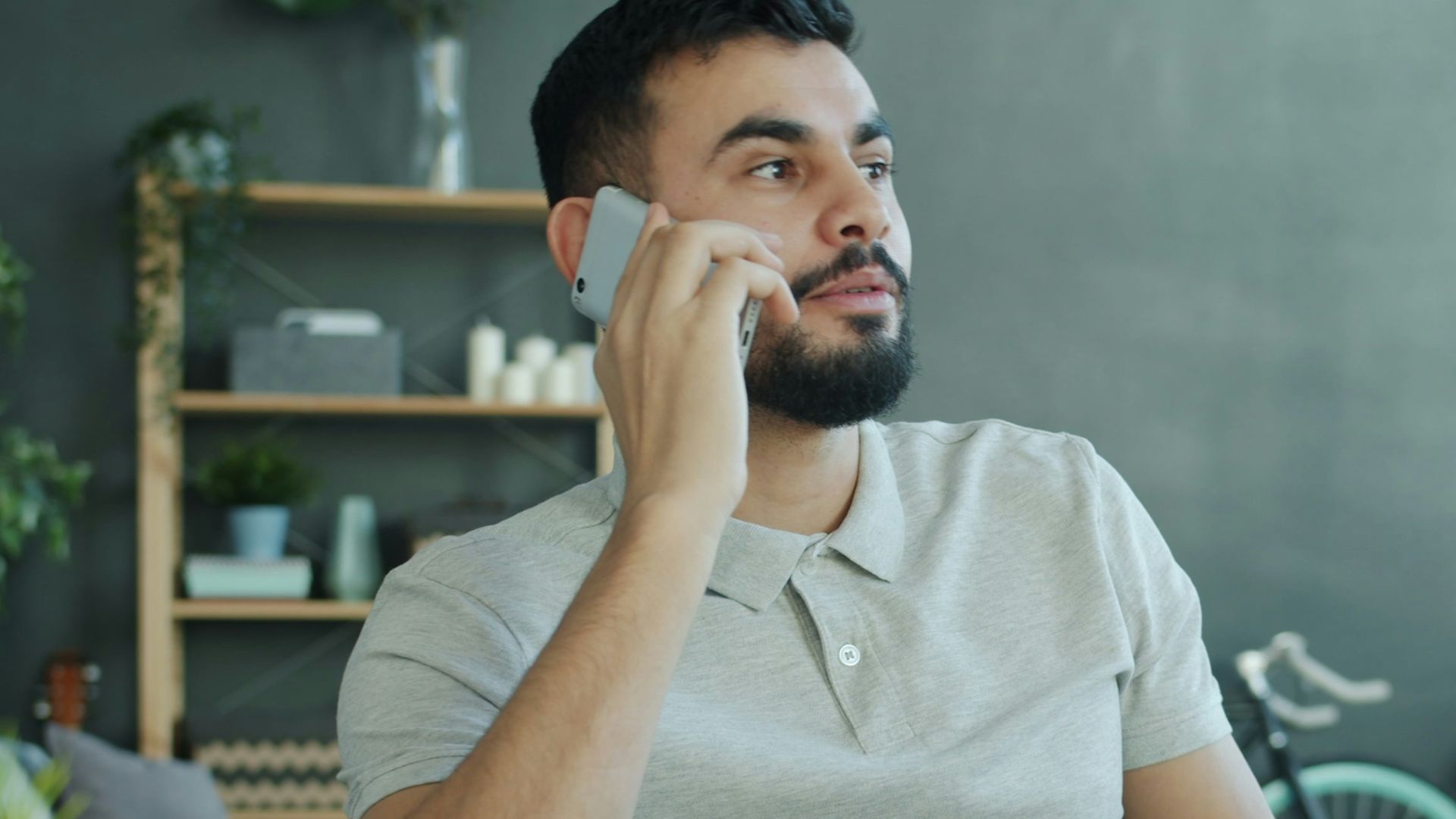 Man talking on phone at desk with laptop.
