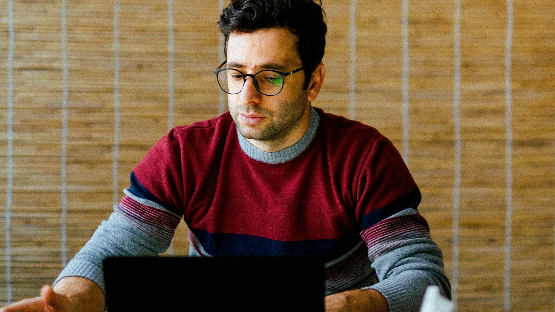 a man sitting in front of a laptop computer