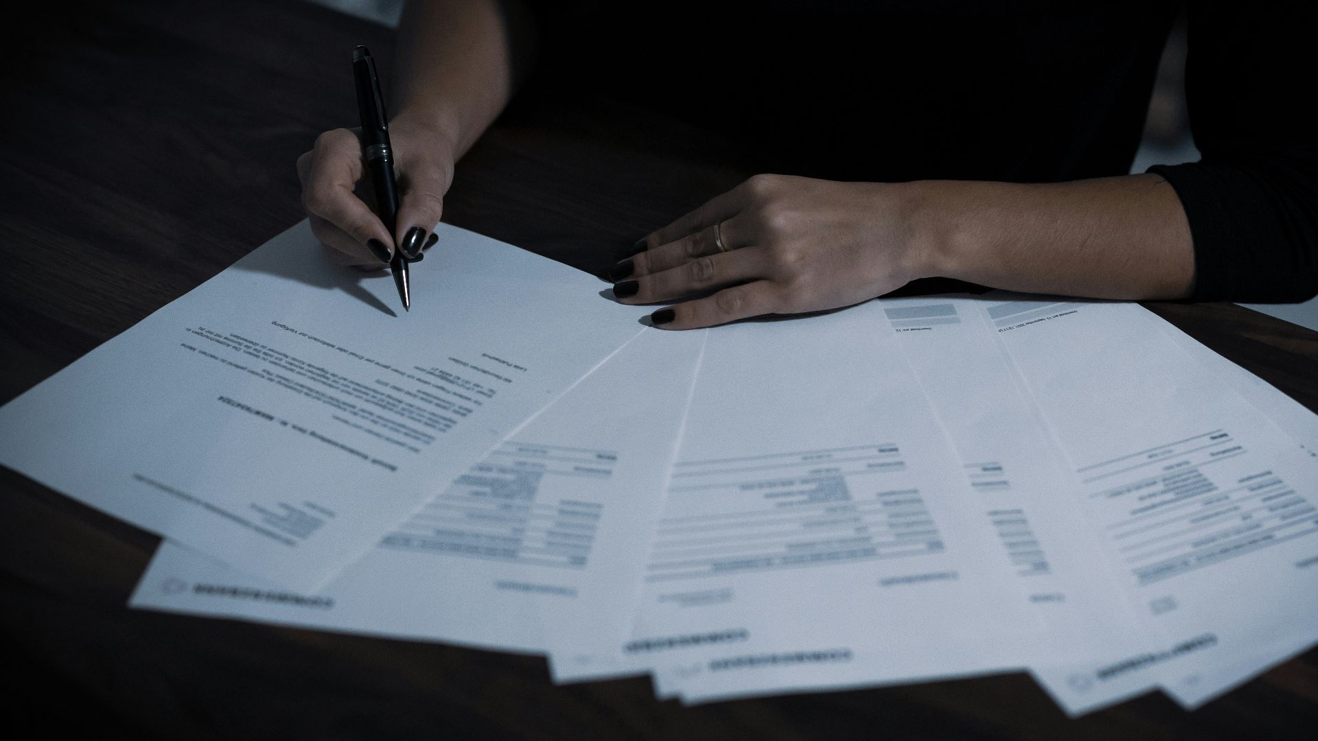 a woman sitting at a table with lots of papers