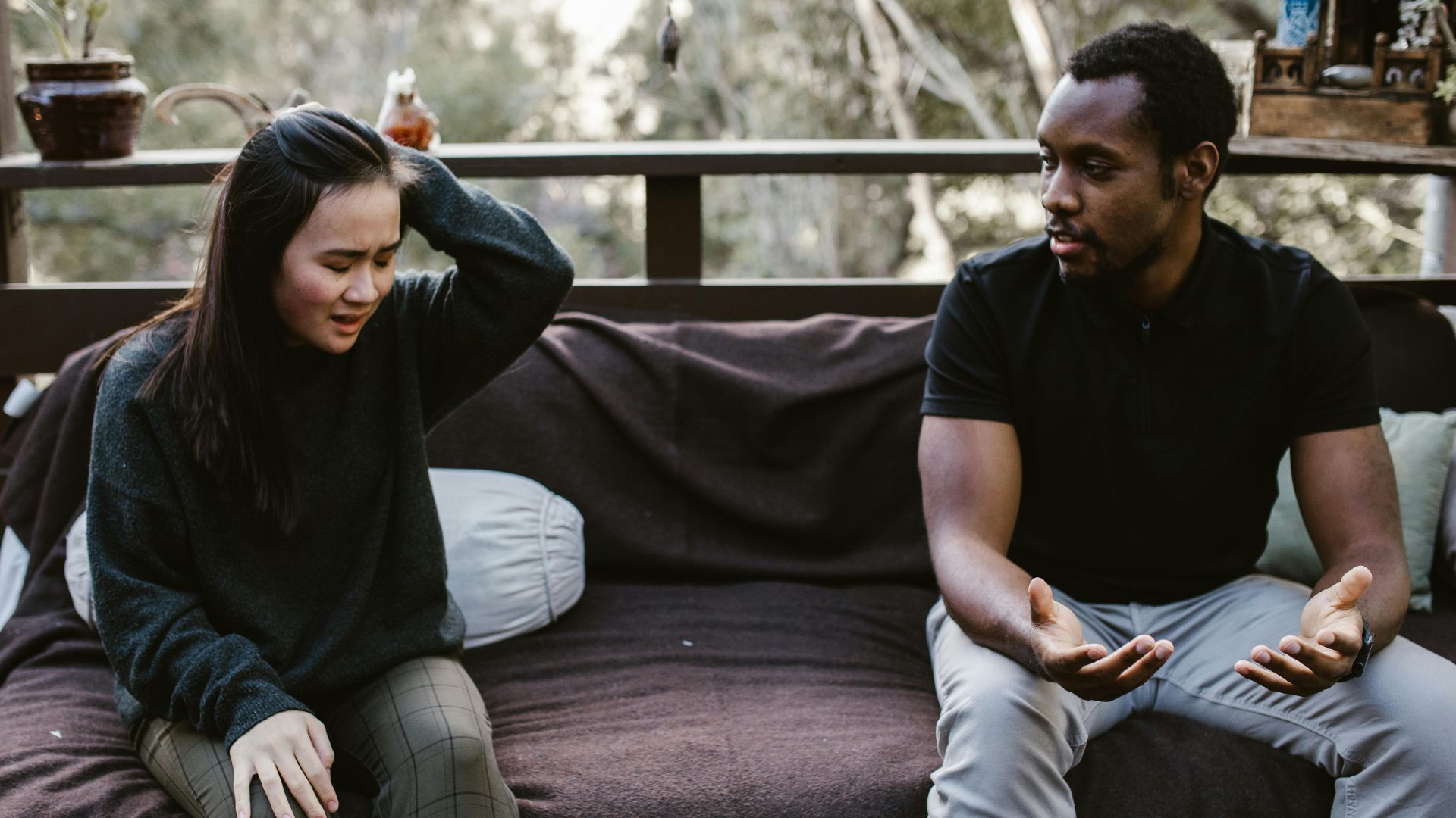 Couple having an intense discussion outdoors. Emotionally charged moment captured.
