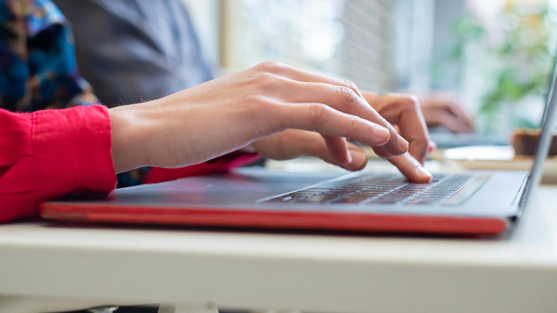 Person typing on a laptop indoors in Portugal, showing productivity and technology use.