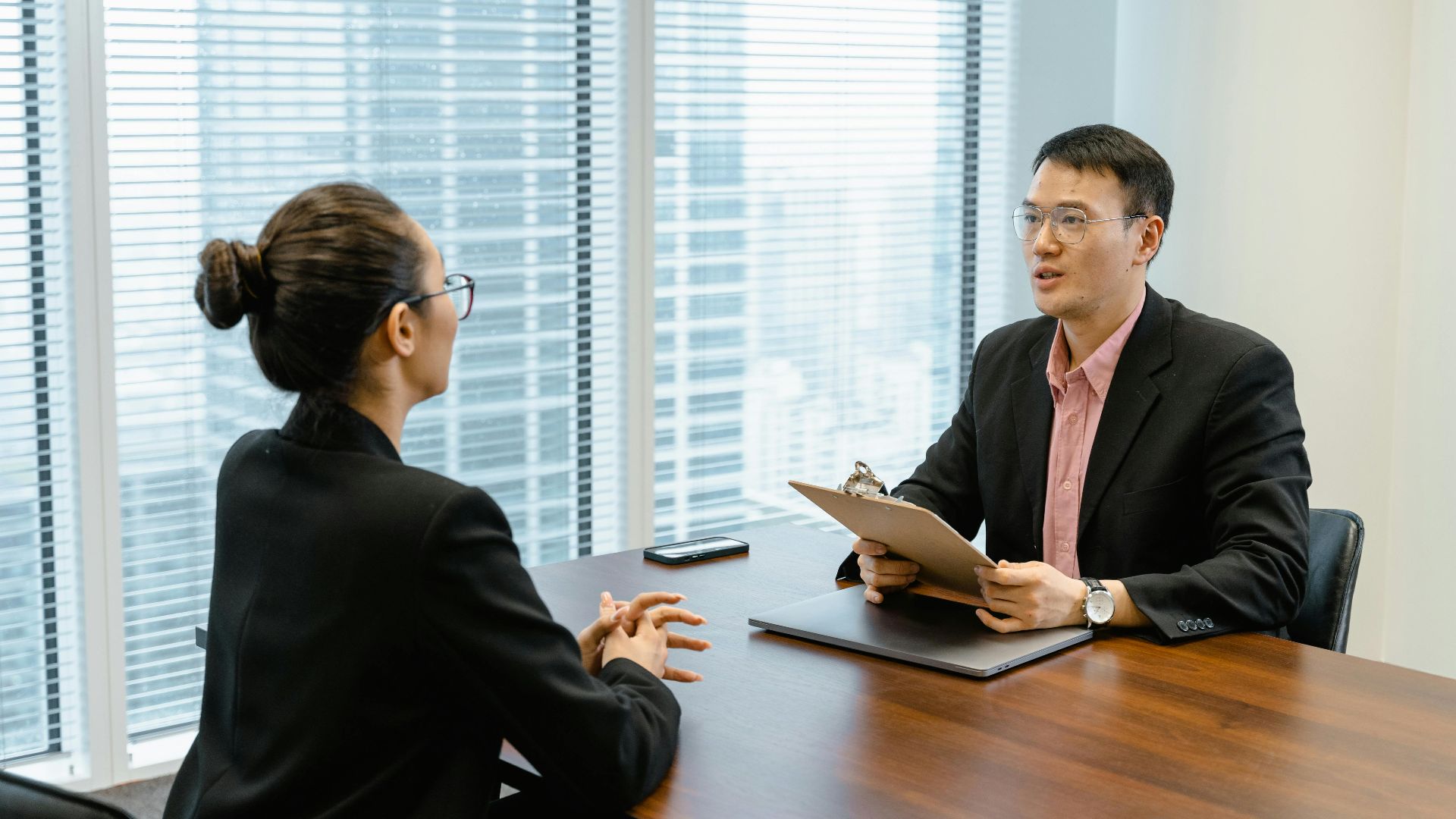Professional business meeting in a modern office with two people discussing over documents.