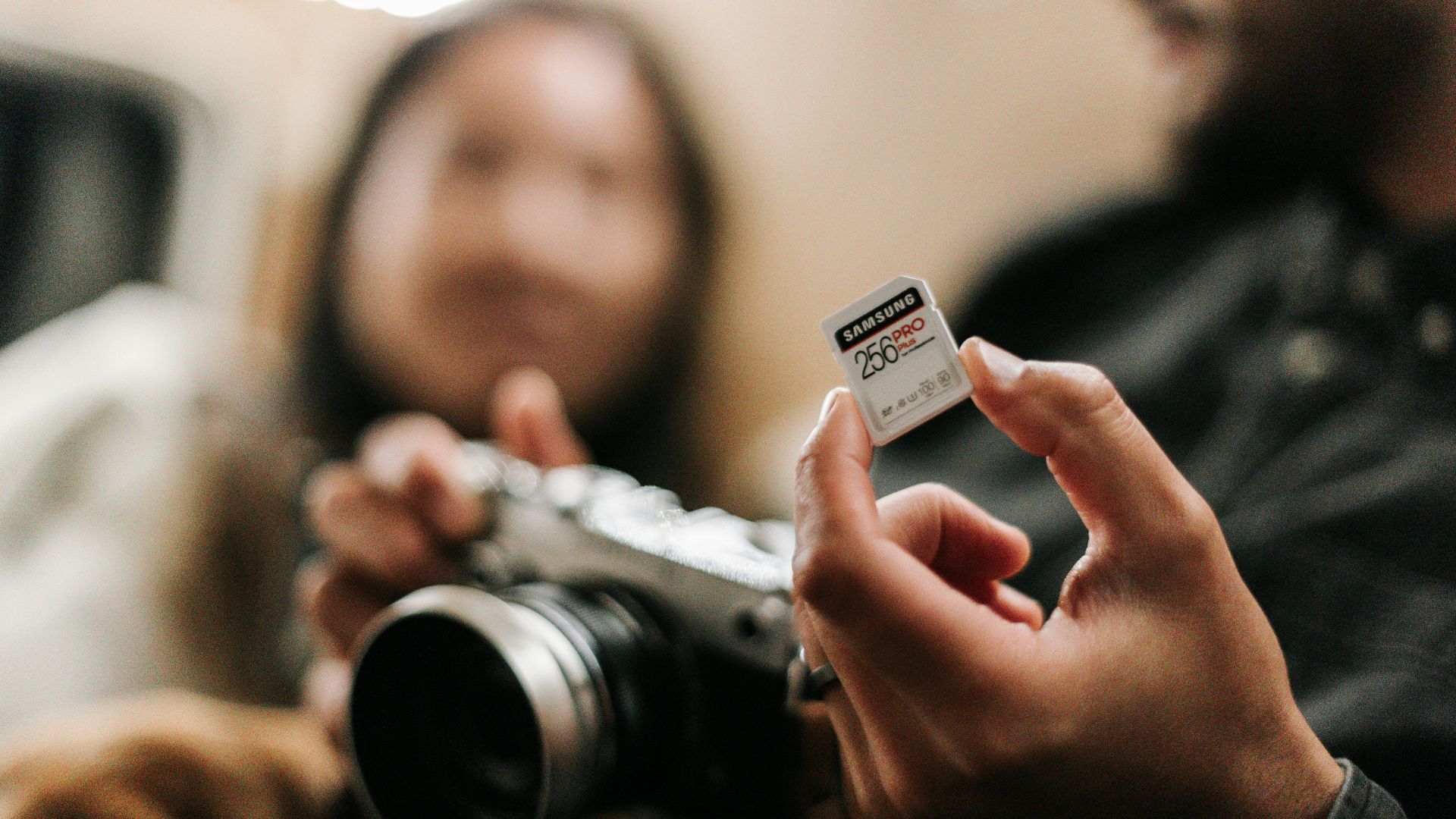 woman holding silver and black camera