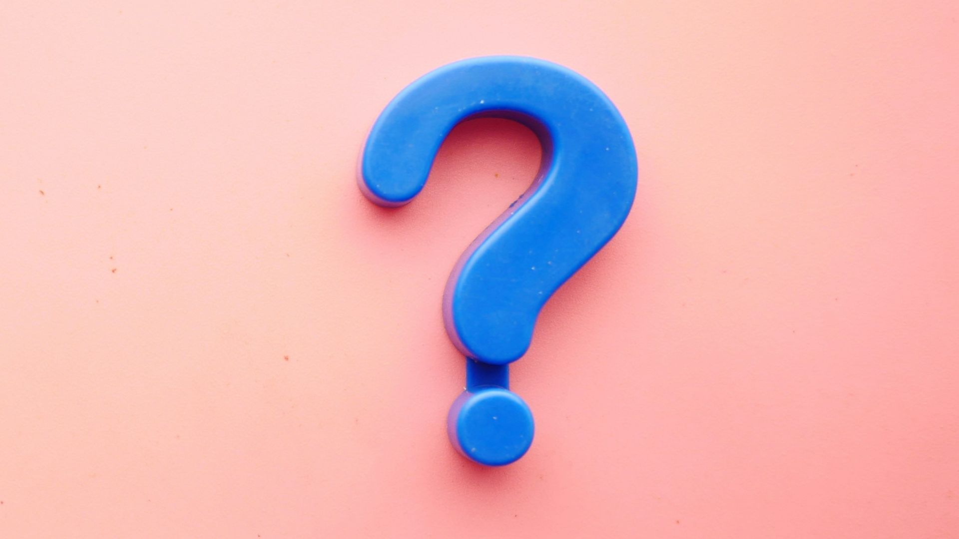 a blue question mark on a pink background