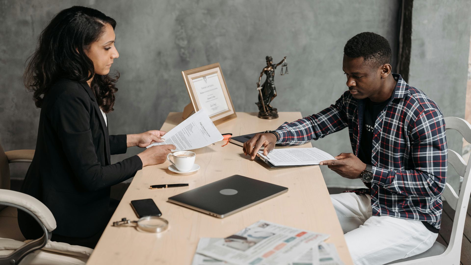 Business professionals discussing documents in a modern office setting.