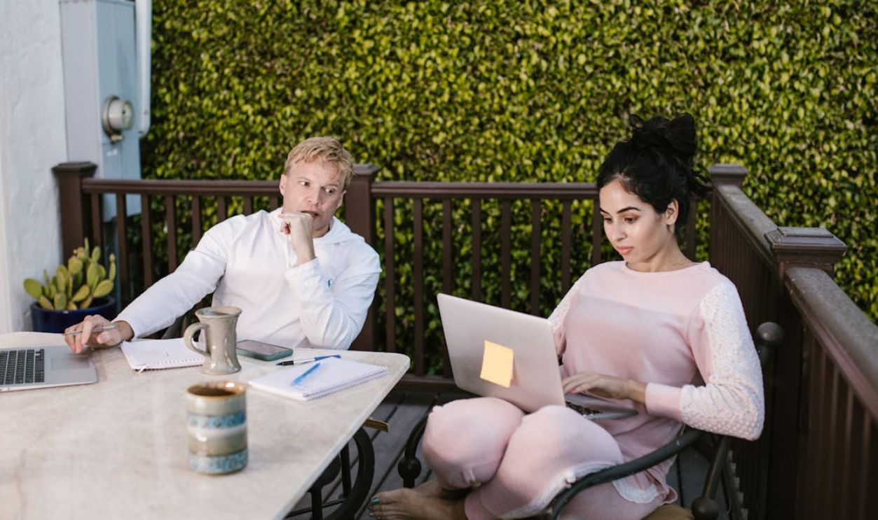 Man with laptop looking at a woman using laptop