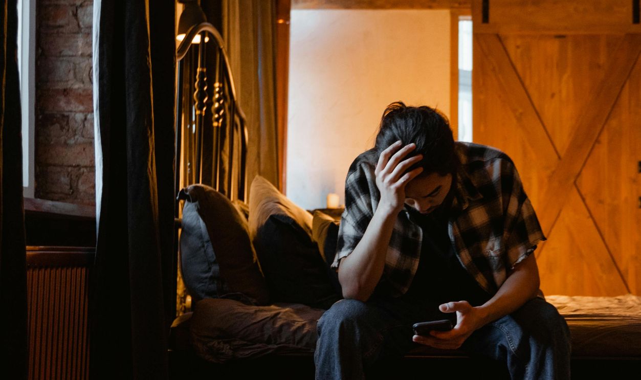 Man in Blue Denim Jeans Sitting on Black Sofa Chair