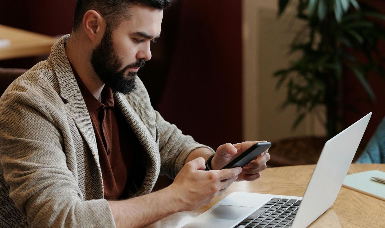 Man in Brown Blazer Holding Smartphone