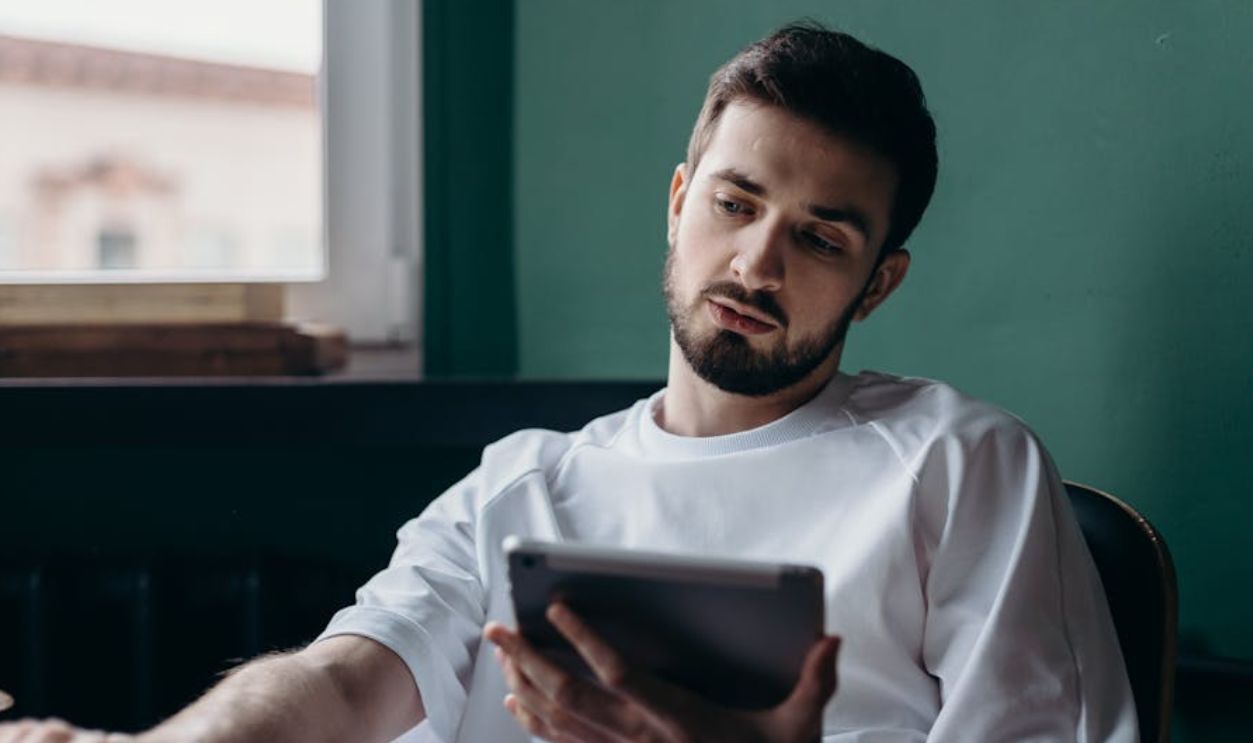 Man in White Shirt Holding an Ipad
