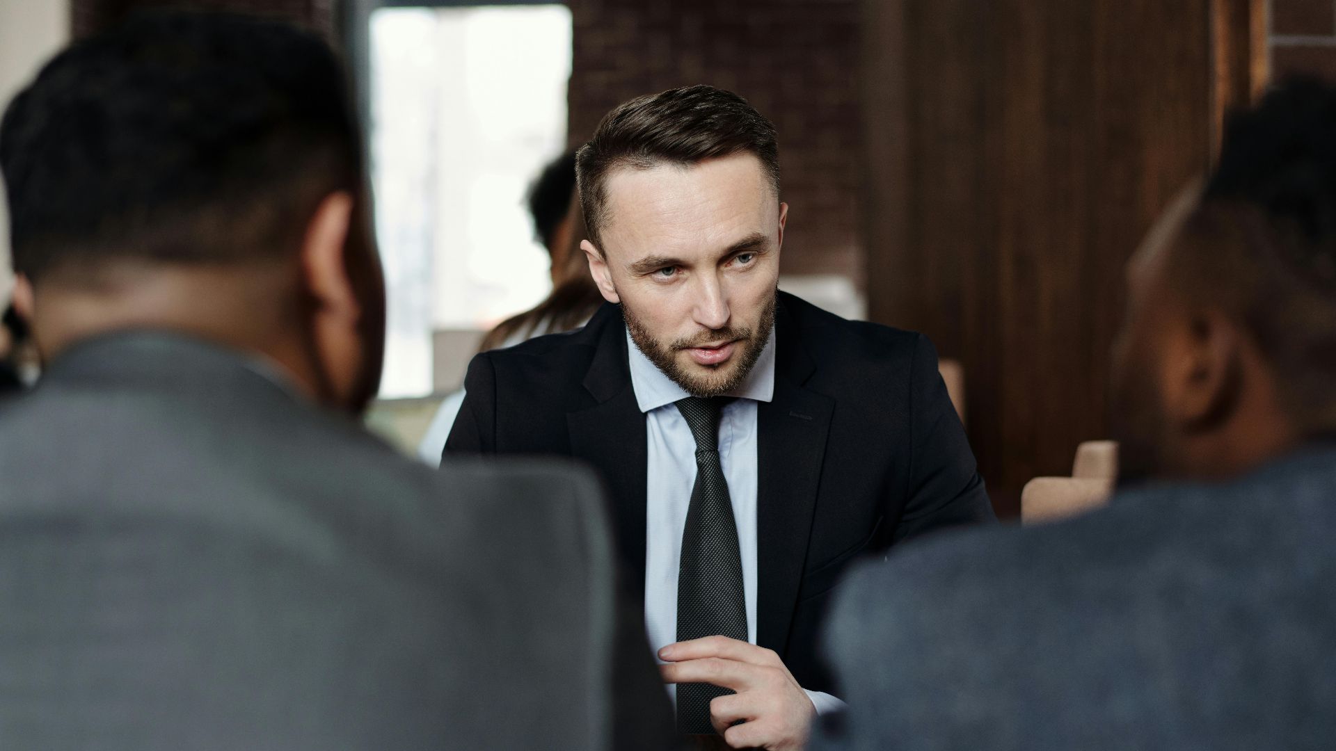Business professionals in suits having a focused meeting indoors.