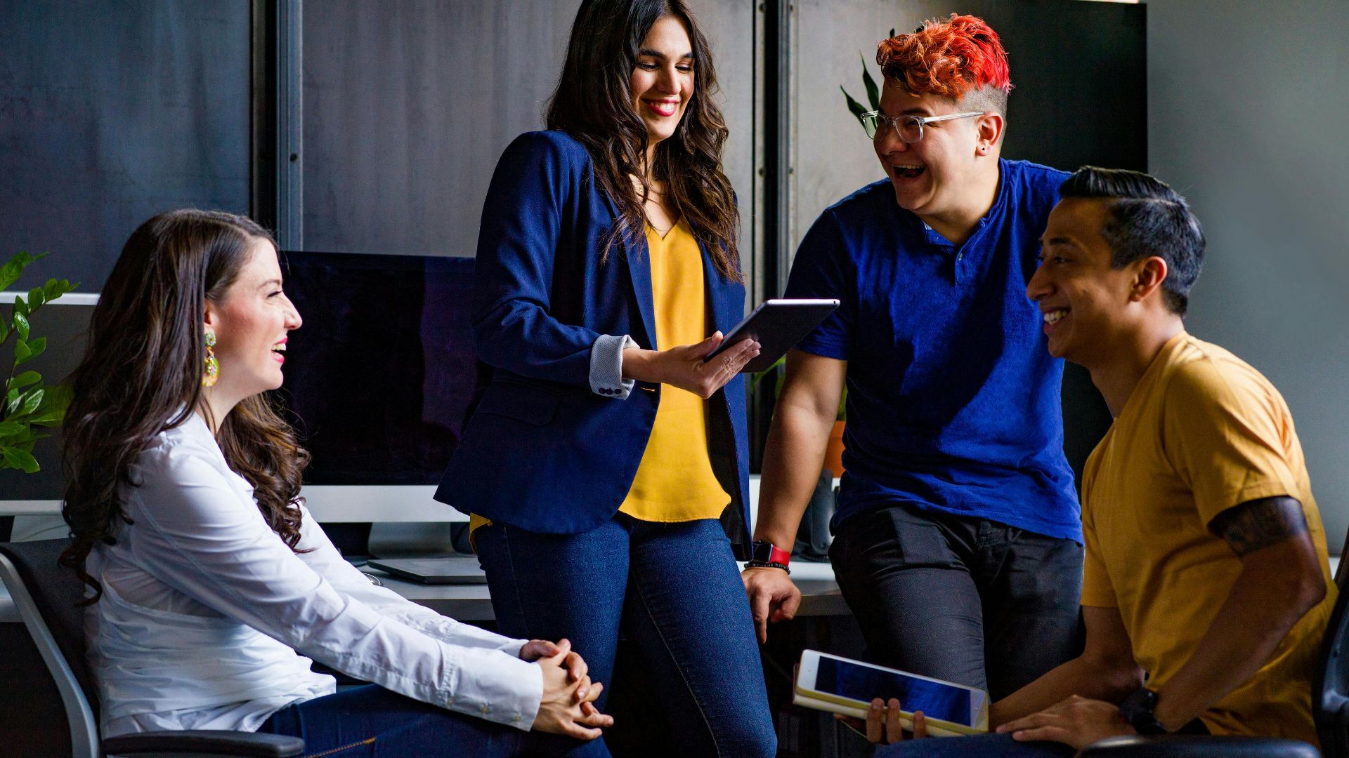 A diverse group of coworkers engaging in a lively discussion in a stylish office environment.