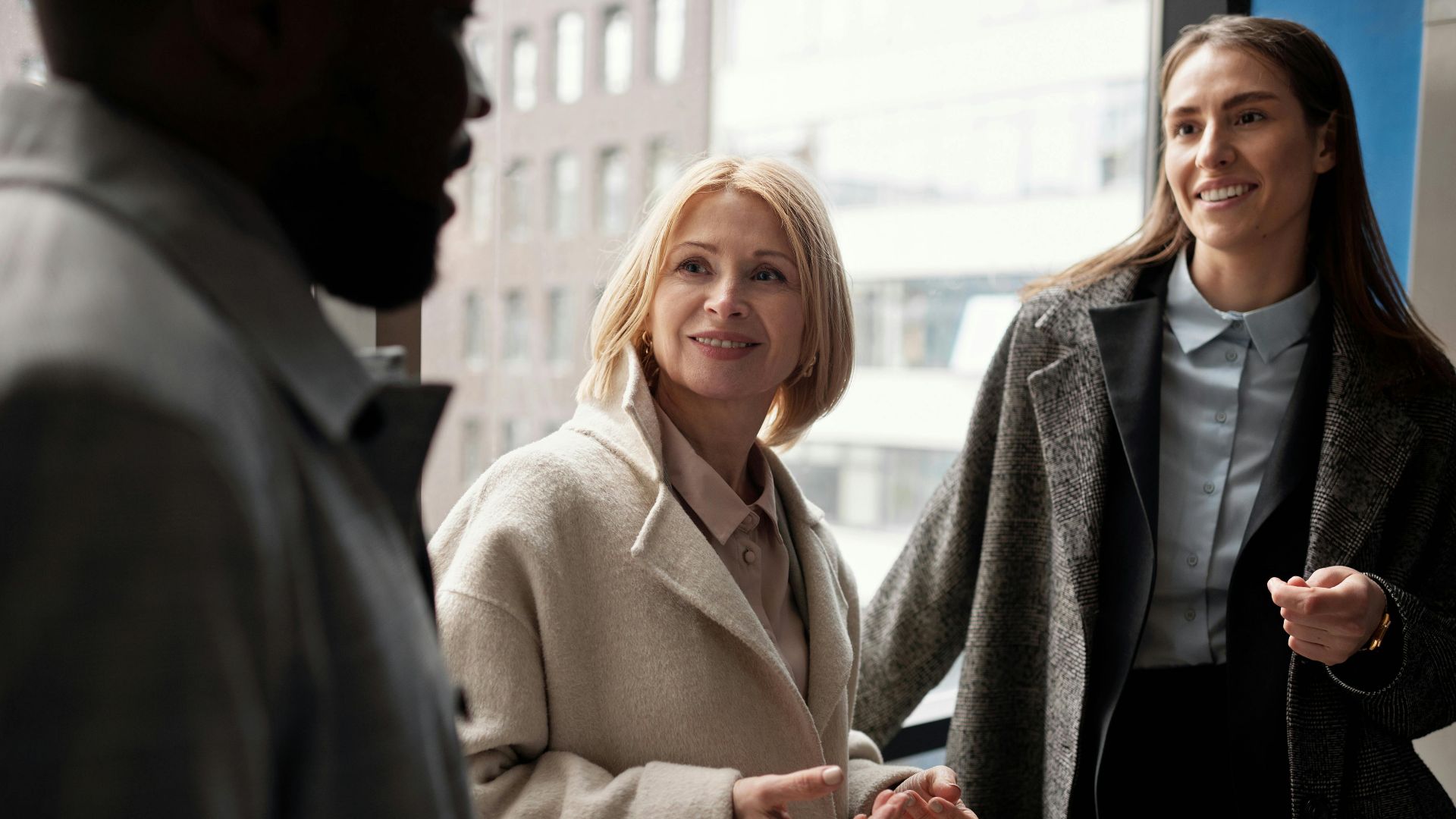 A diverse group of business professionals conversing in an urban office setting.