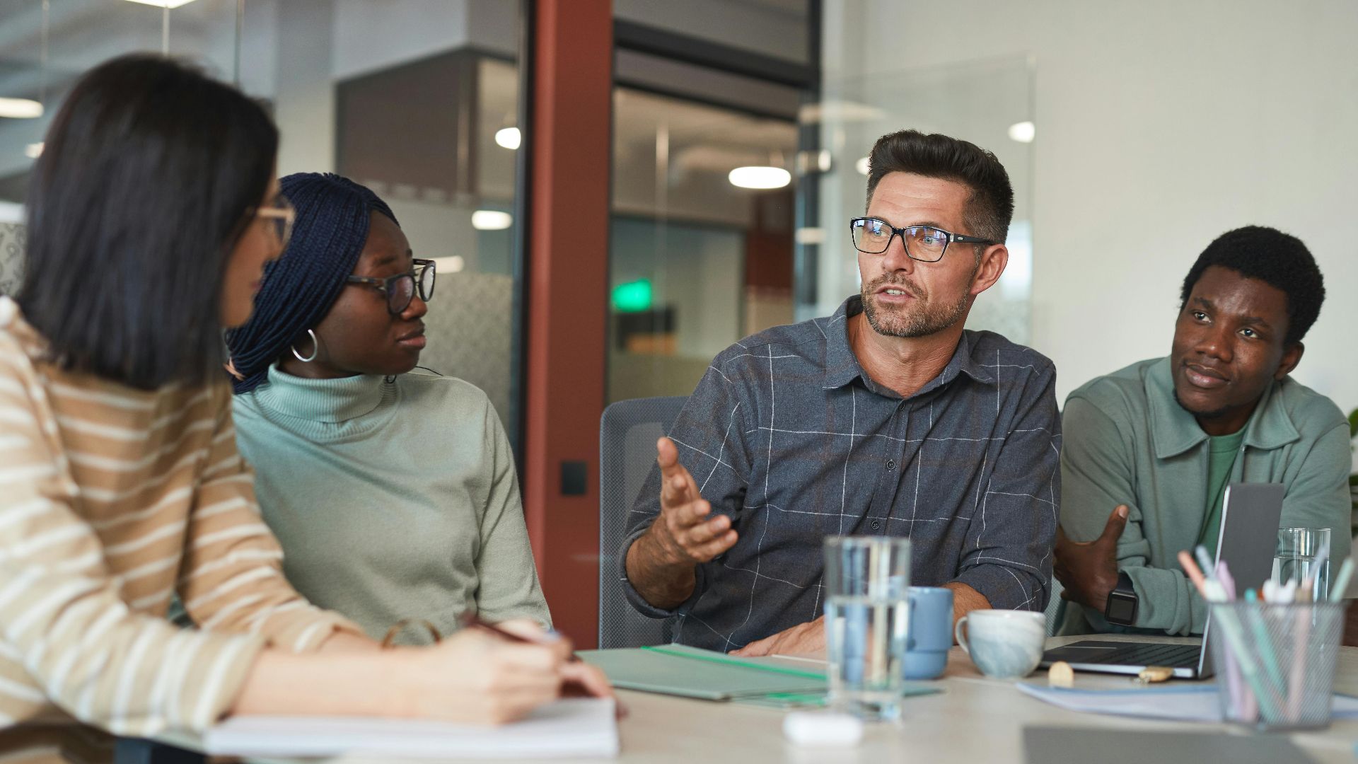 A diverse group of professionals having an animated discussion in a modern office setting.