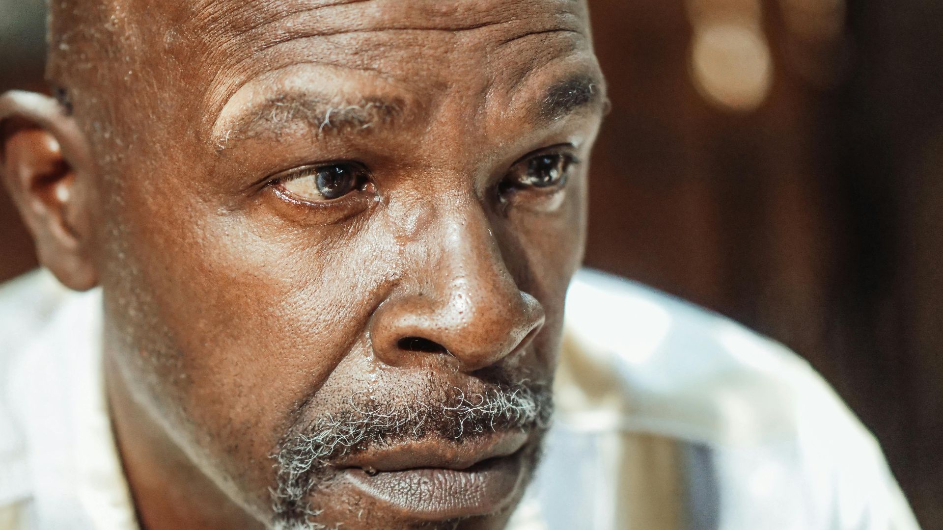 Close-up portrait of an elderly man with a contemplative expression, highlighting emotions of introspection and reflection.