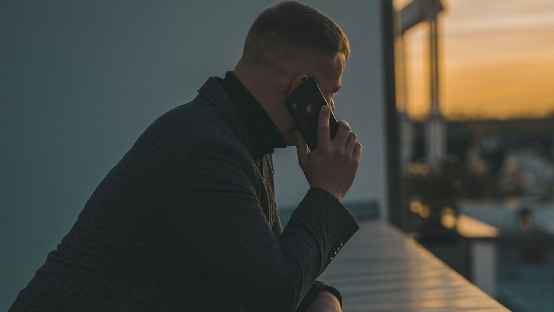 man in black long sleeve shirt sitting by the table
