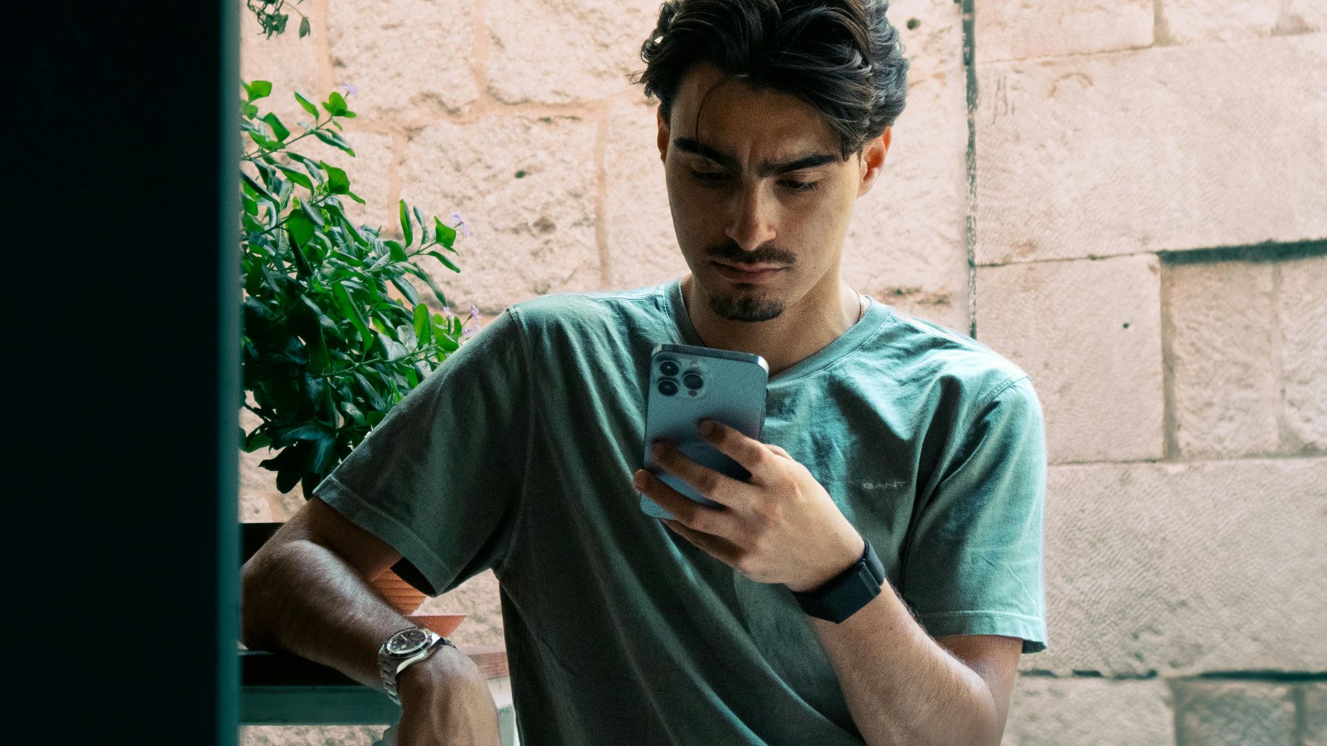 A young man in casual attire checking his phone outside in Split, Croatia.