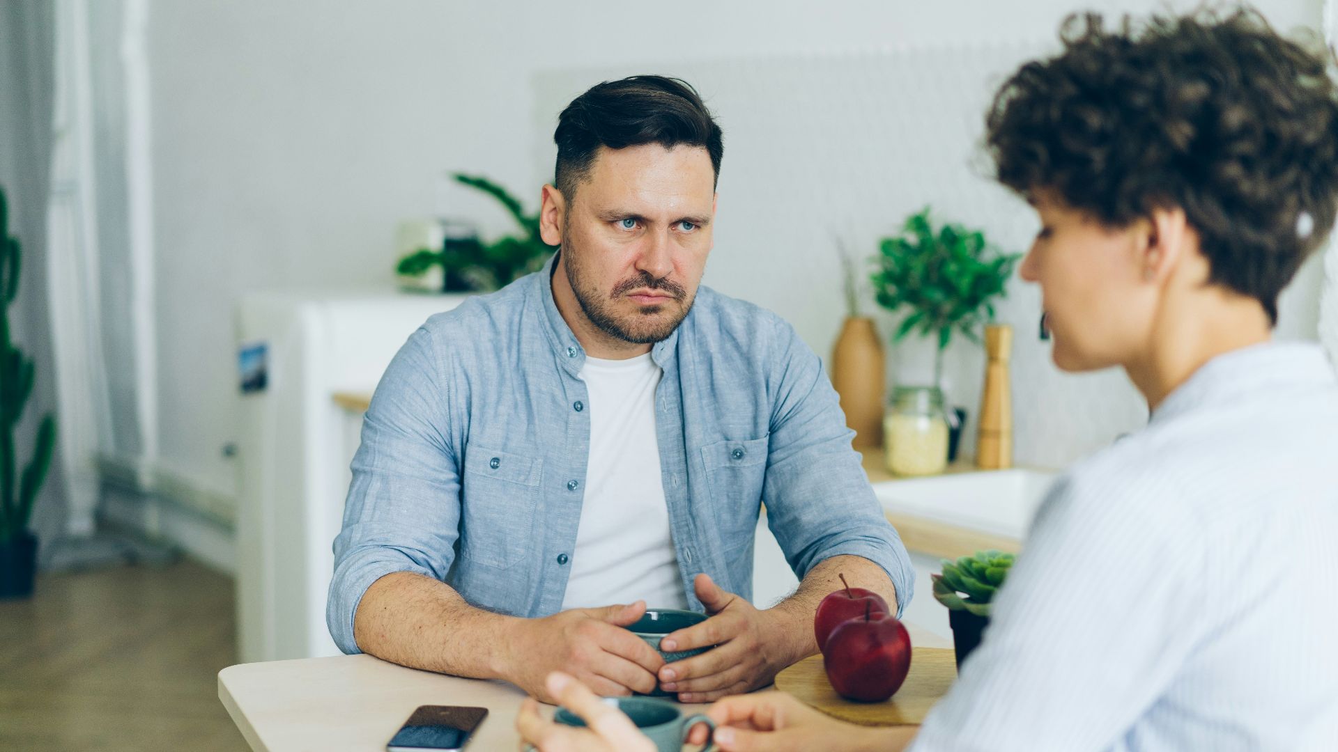 a man sitting at a table talking to a woman
