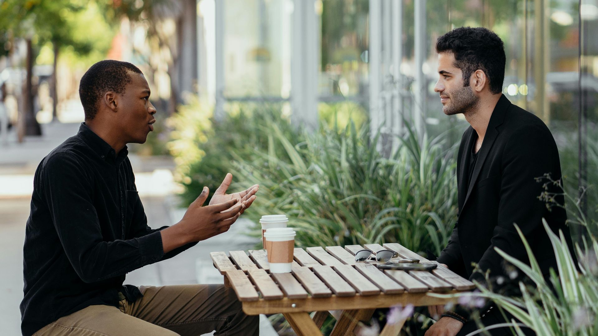 Two men having a business meeting at an outdoor café setting.