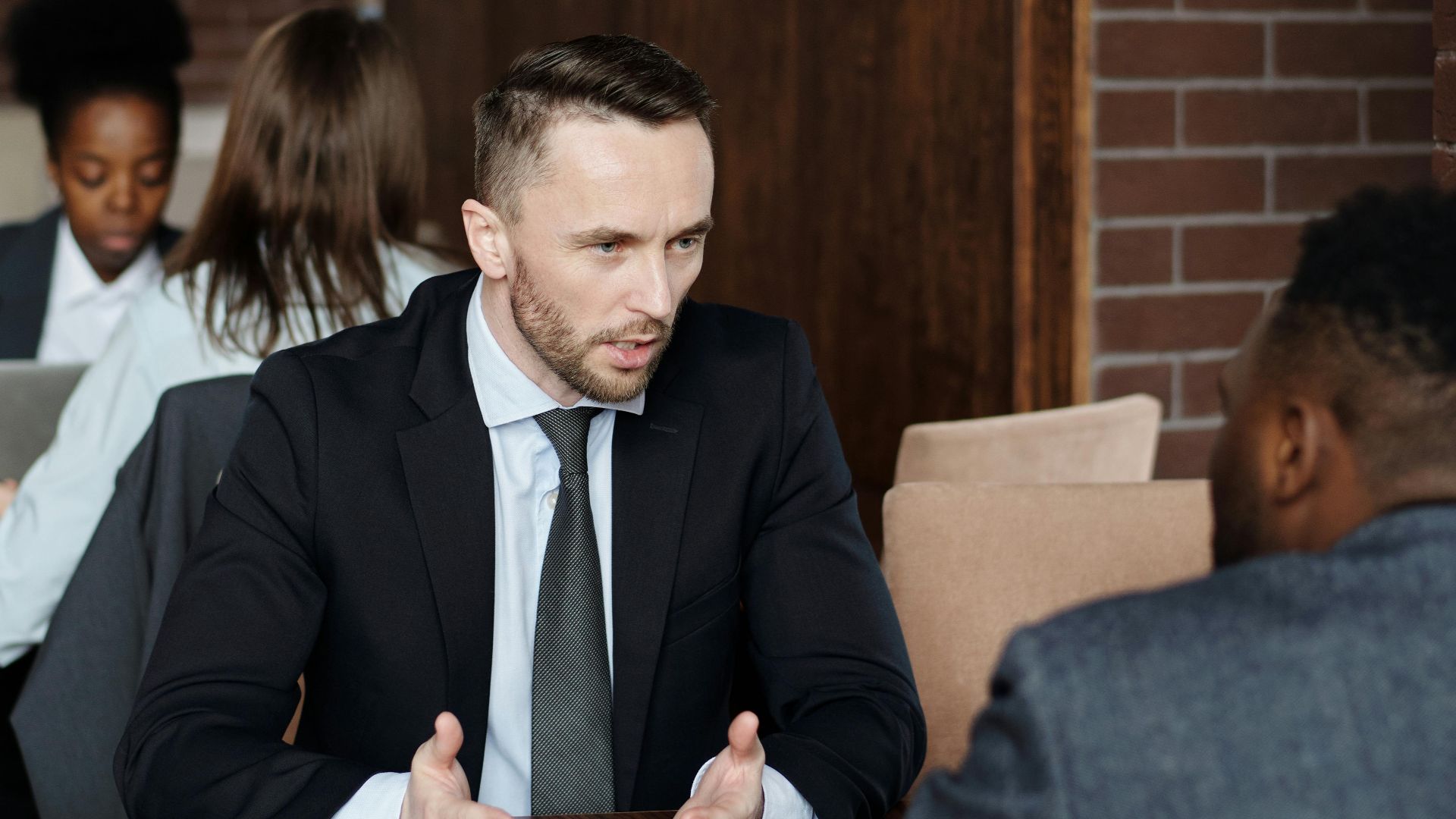 Professionals in suits having a focused business discussion in a stylish café.