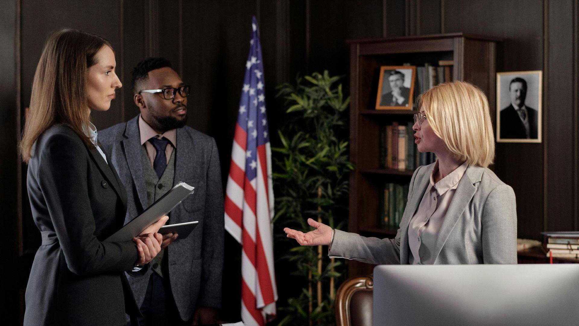 Diverse group of business professionals engaging in a discussion in a modern office setting.