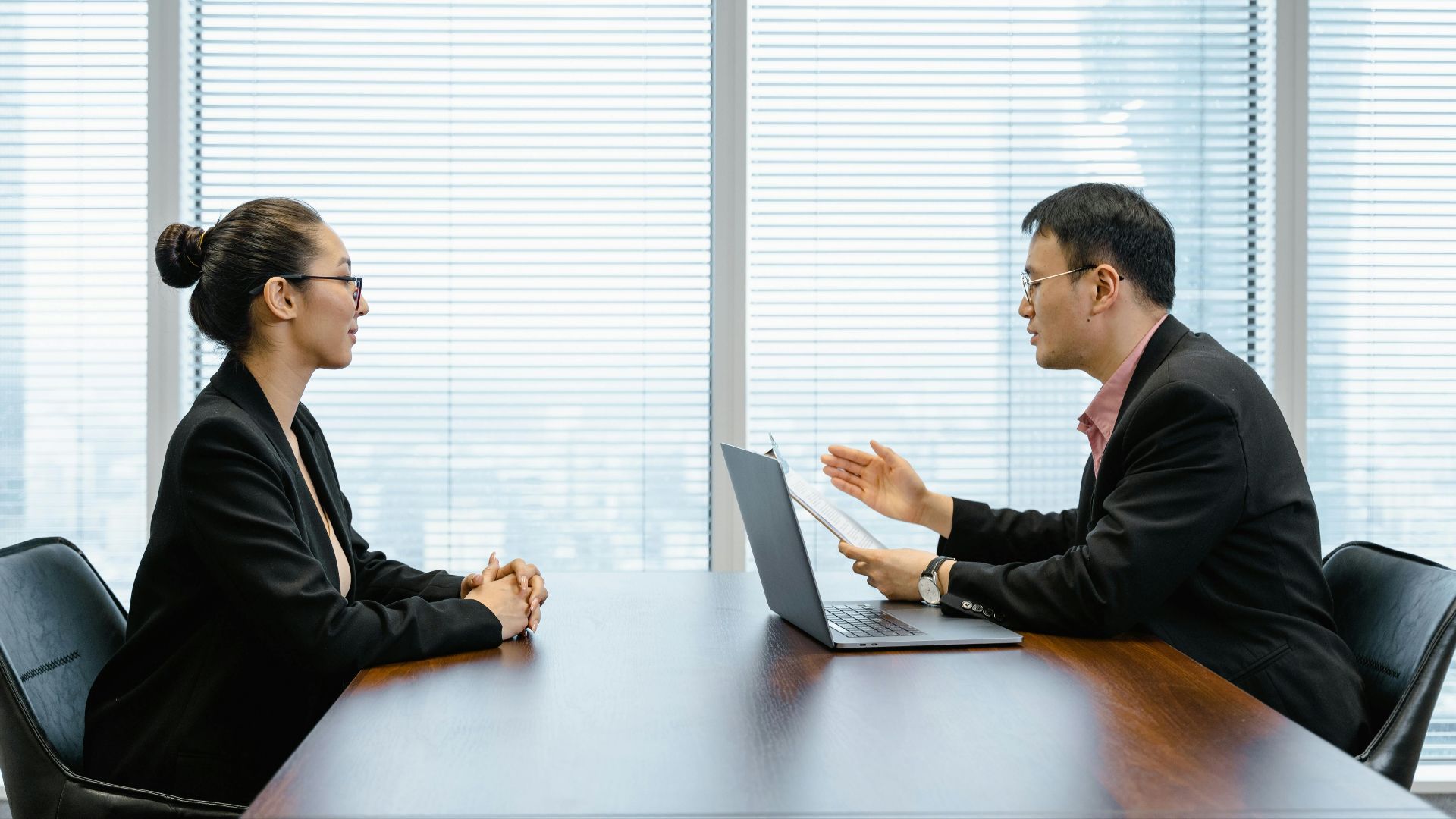 Two businesspeople engaged in a discussion during a professional meeting in an office setting.