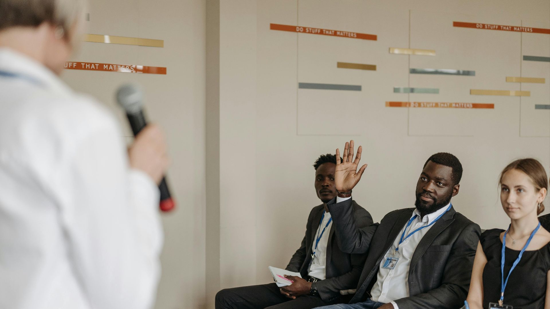 Engaged participants in a business conference, raising questions to the speaker.