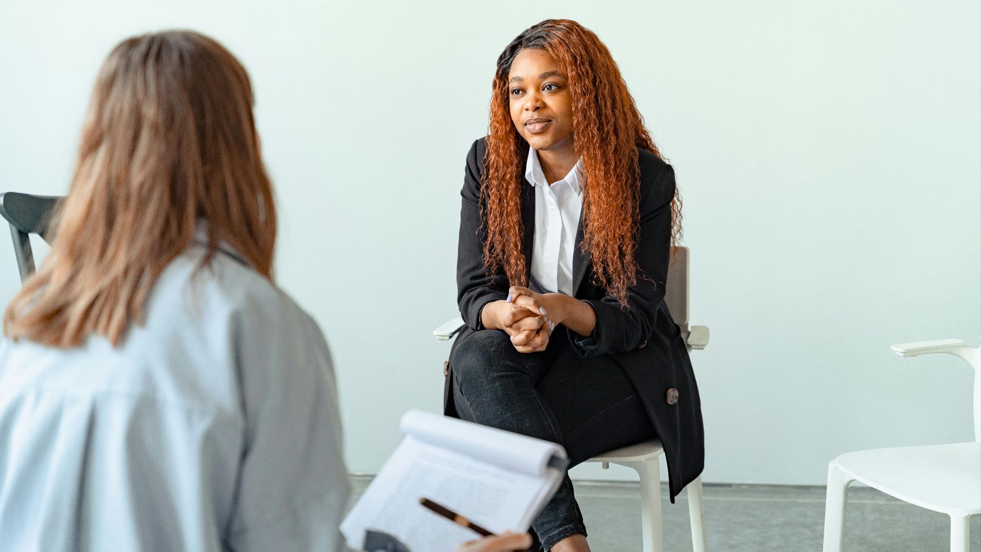 Therapist interacting with client during a counseling session indoors.