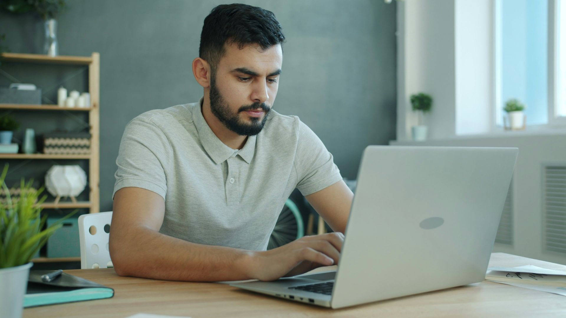 Man typing on a laptop at a desk.