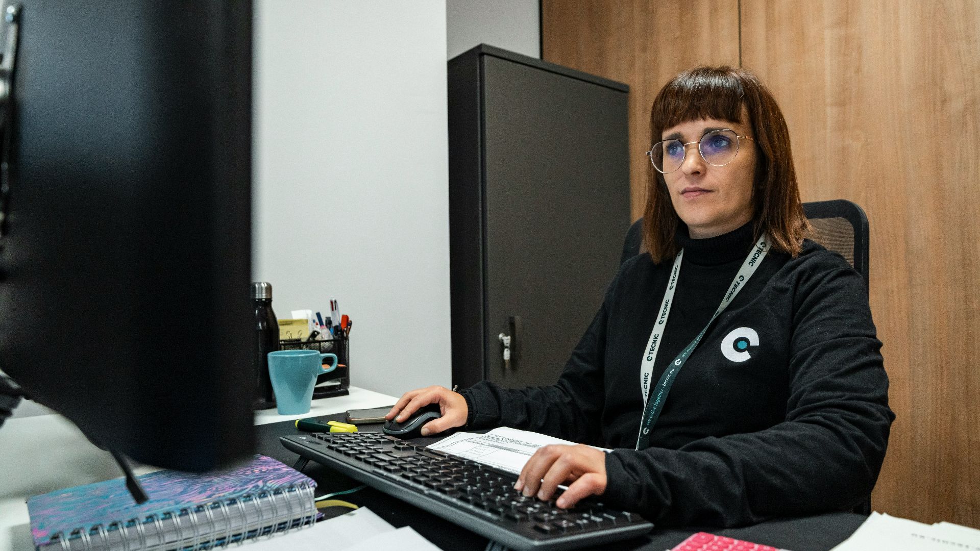 A woman is working at her office desk.