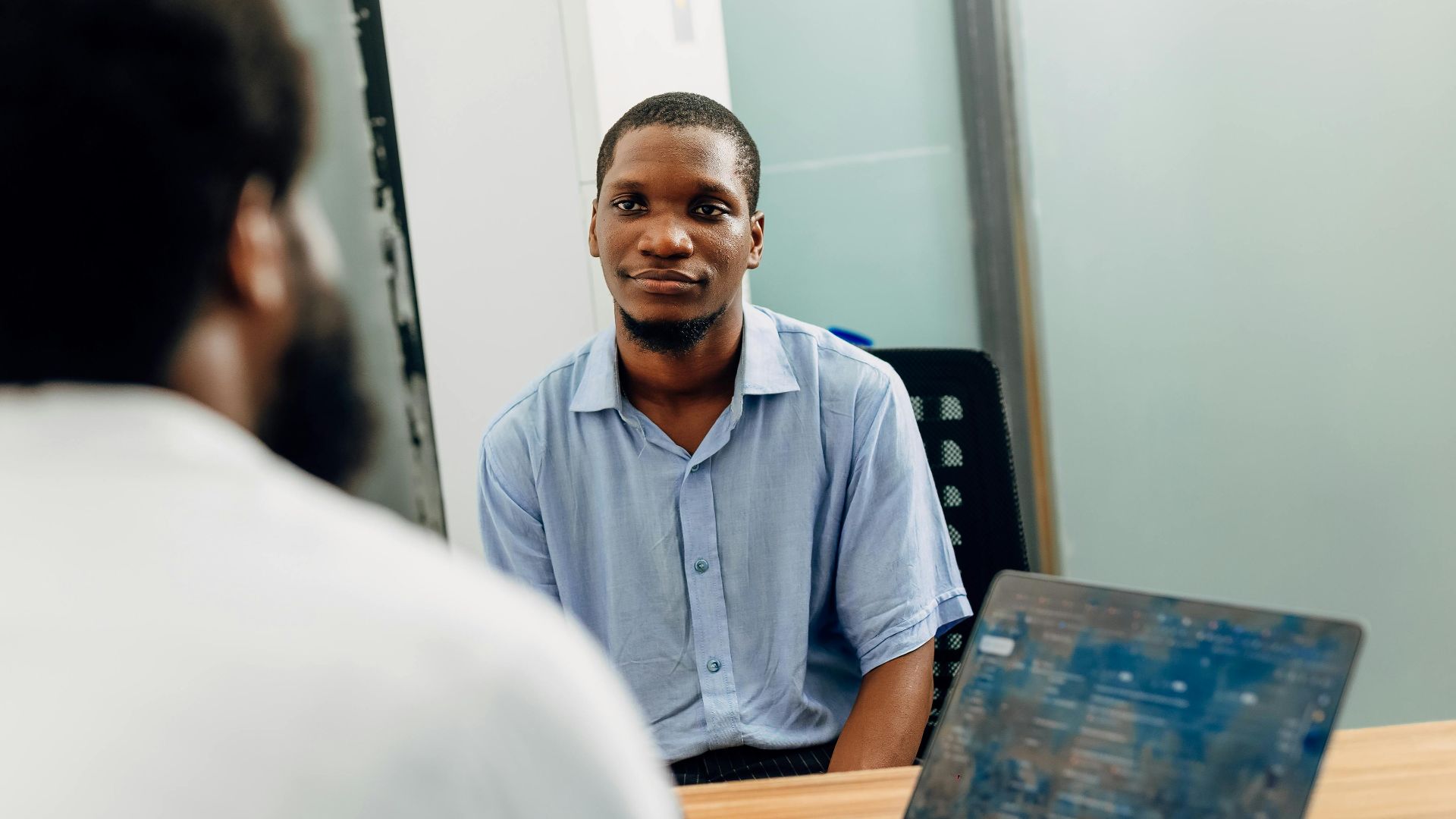 A business meeting in a modern office in Lagos, Nigeria featuring two professionals engaged in a discussion.