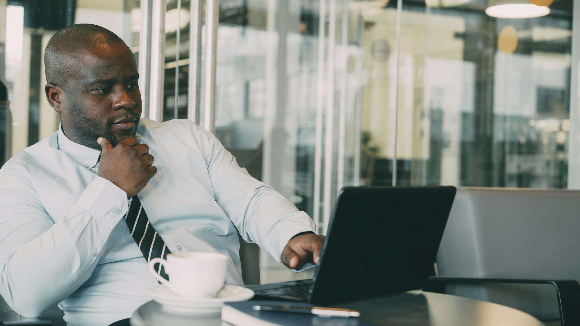 Man in shirt and tie working on laptop