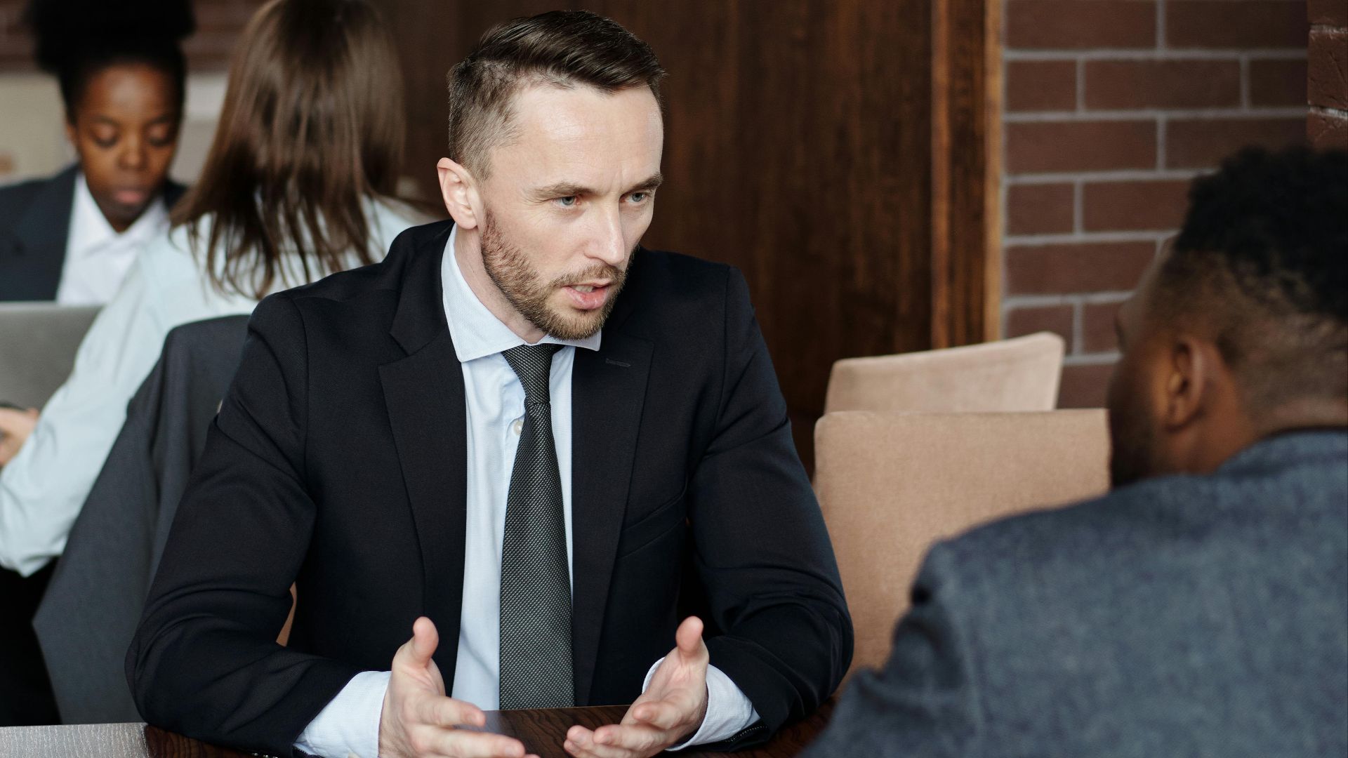 Professionals in suits having a focused business discussion in a stylish café.