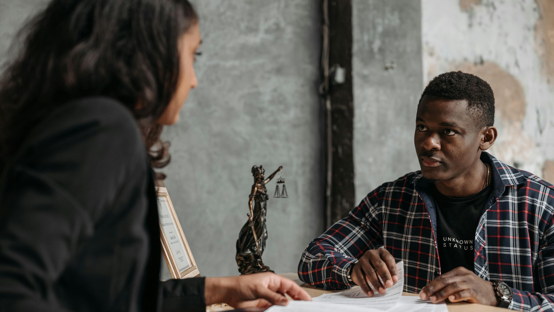 Business meeting between a lawyer and client in a professional office setting.