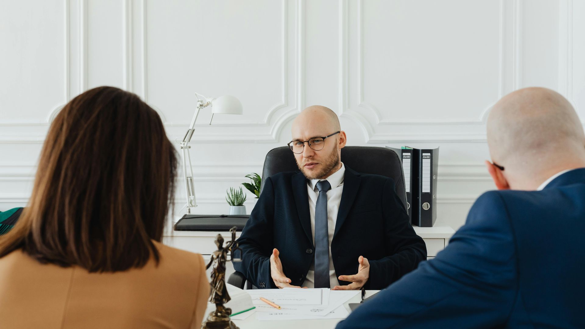 A professional business meeting with a lawyer and clients in a modern office setting.