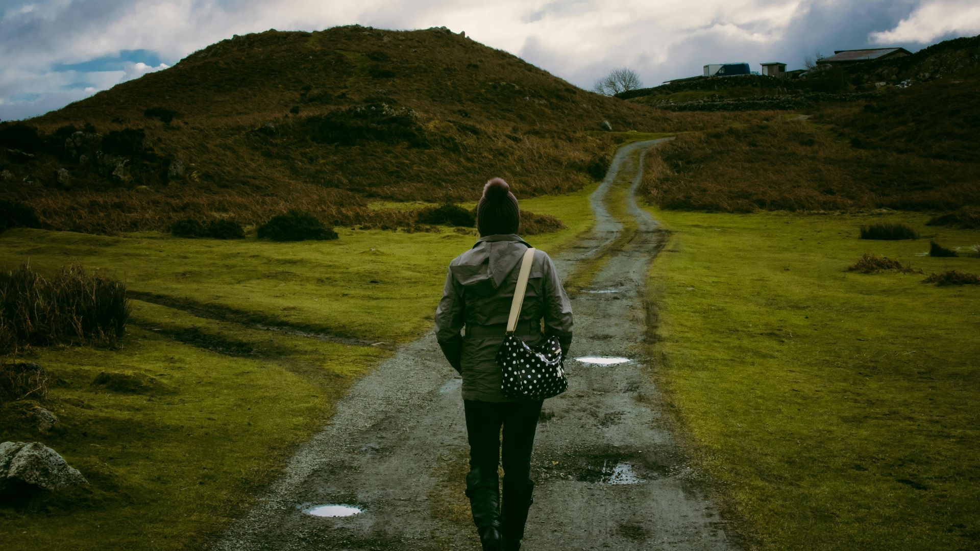 Person walking on a scenic countryside trail, embracing solitude and nature.