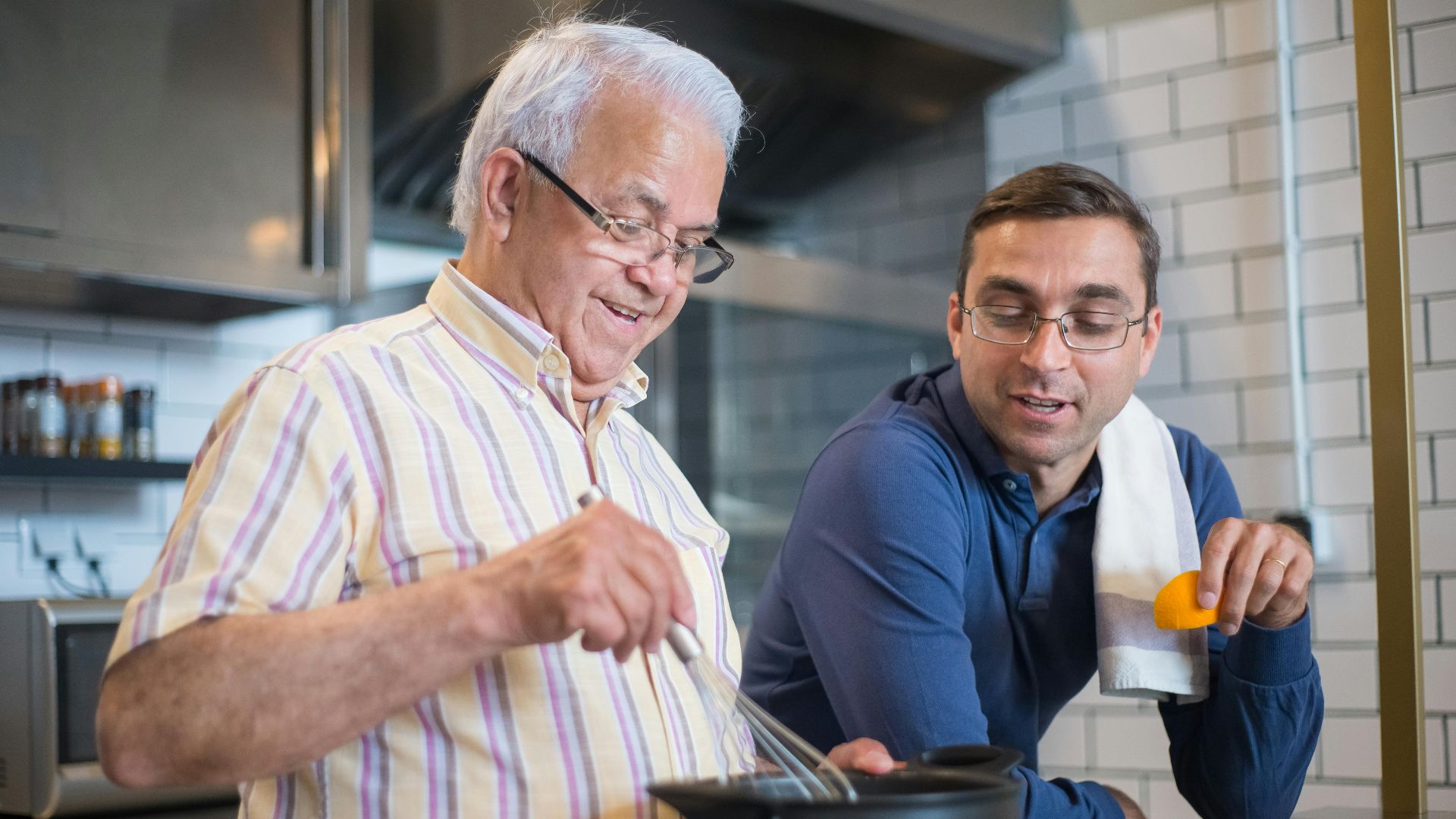 A father and son enjoying quality time cooking together, fostering a warm family bond.