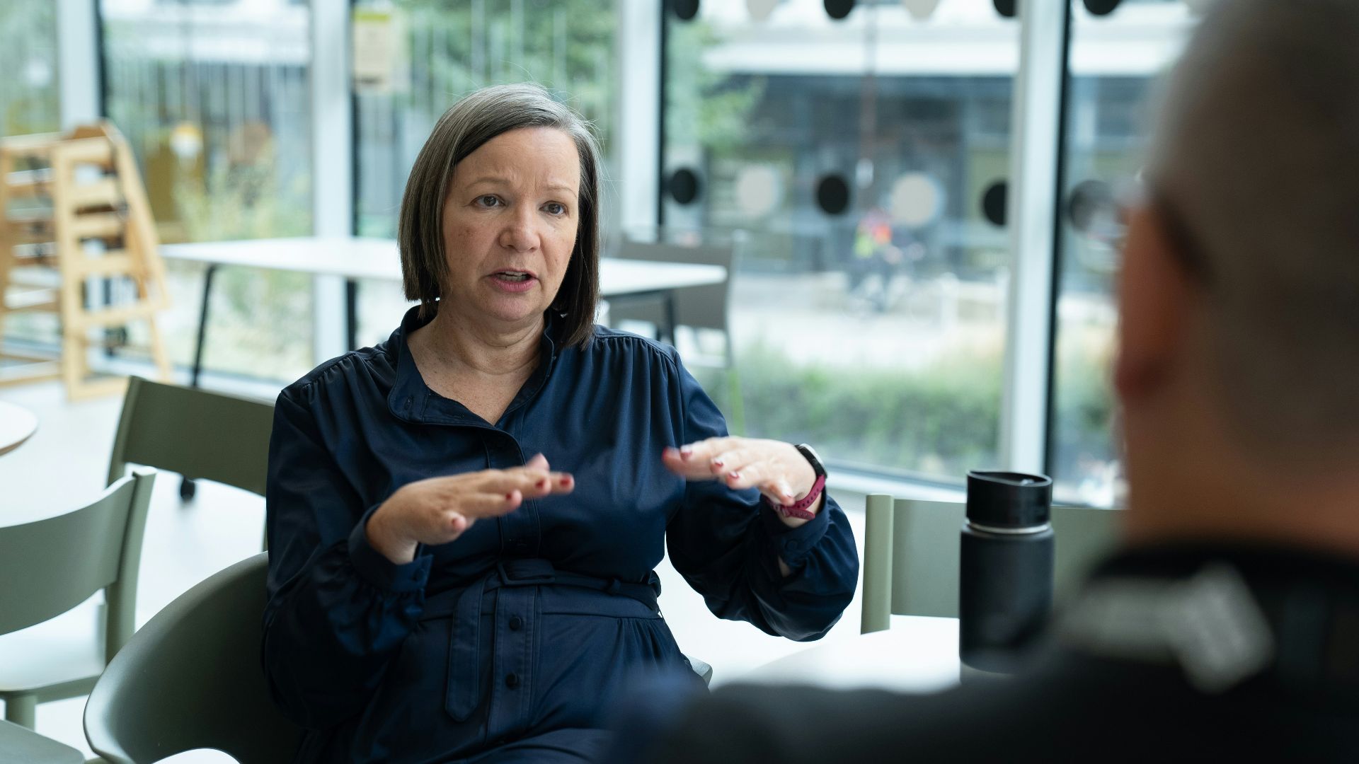 Woman gesturing while talking to person