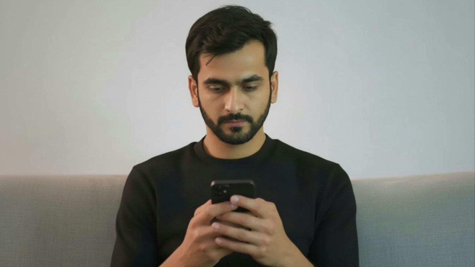 Man in black shirt looking at smartphone