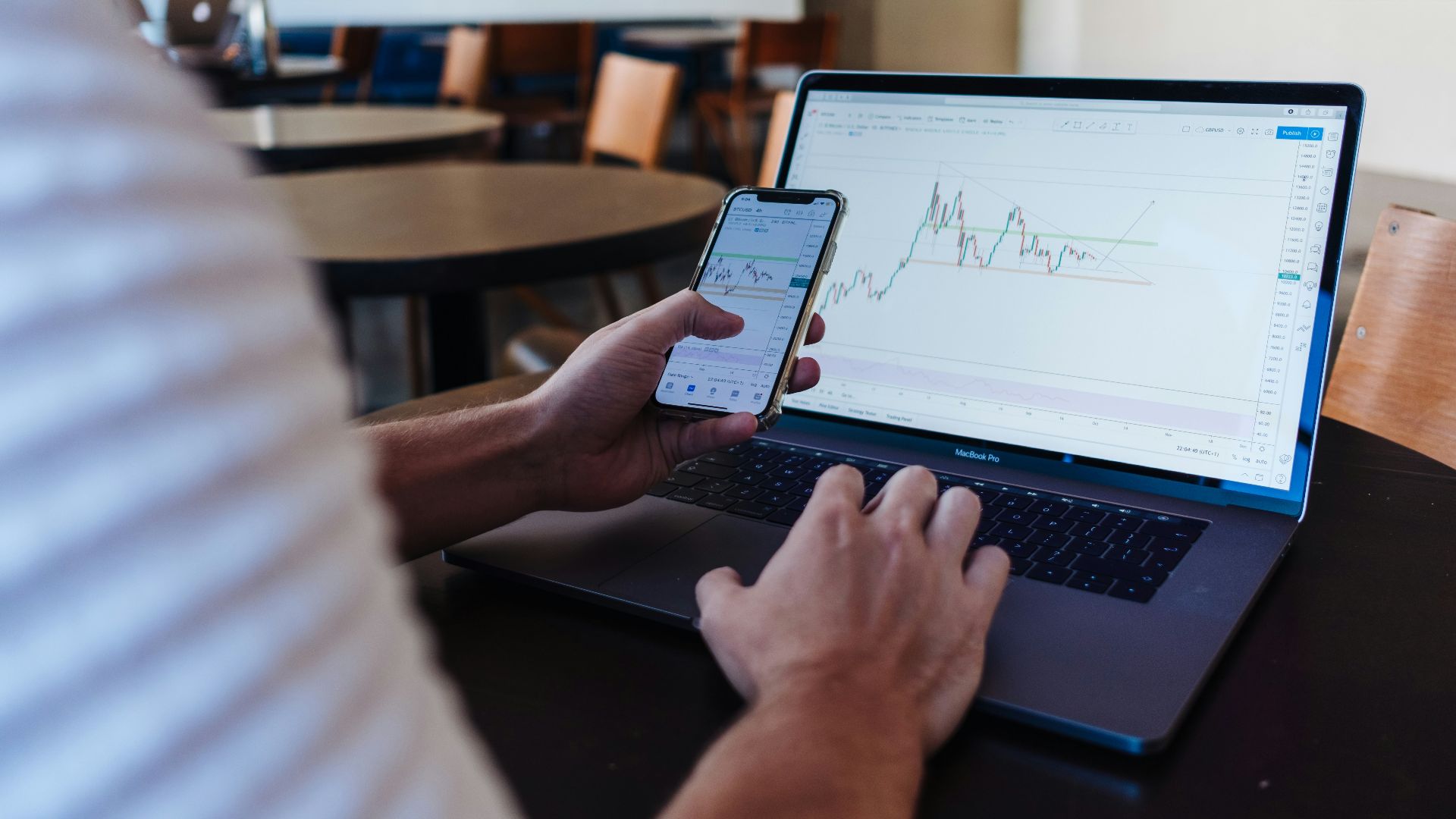 person using smartphone and MacBook Pro