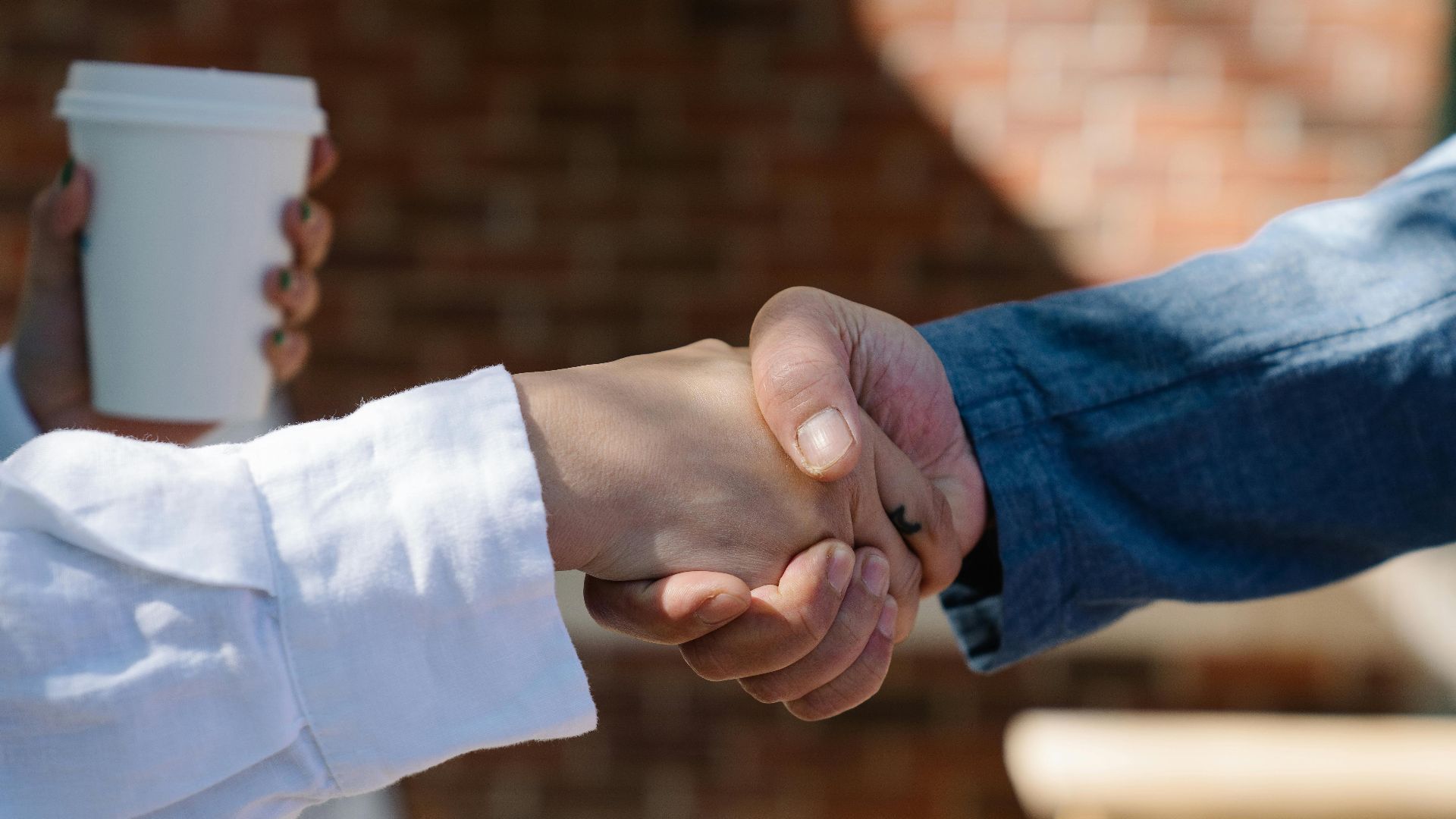 Close-up of a handshake between two adults, symbolizing agreement or partnership.