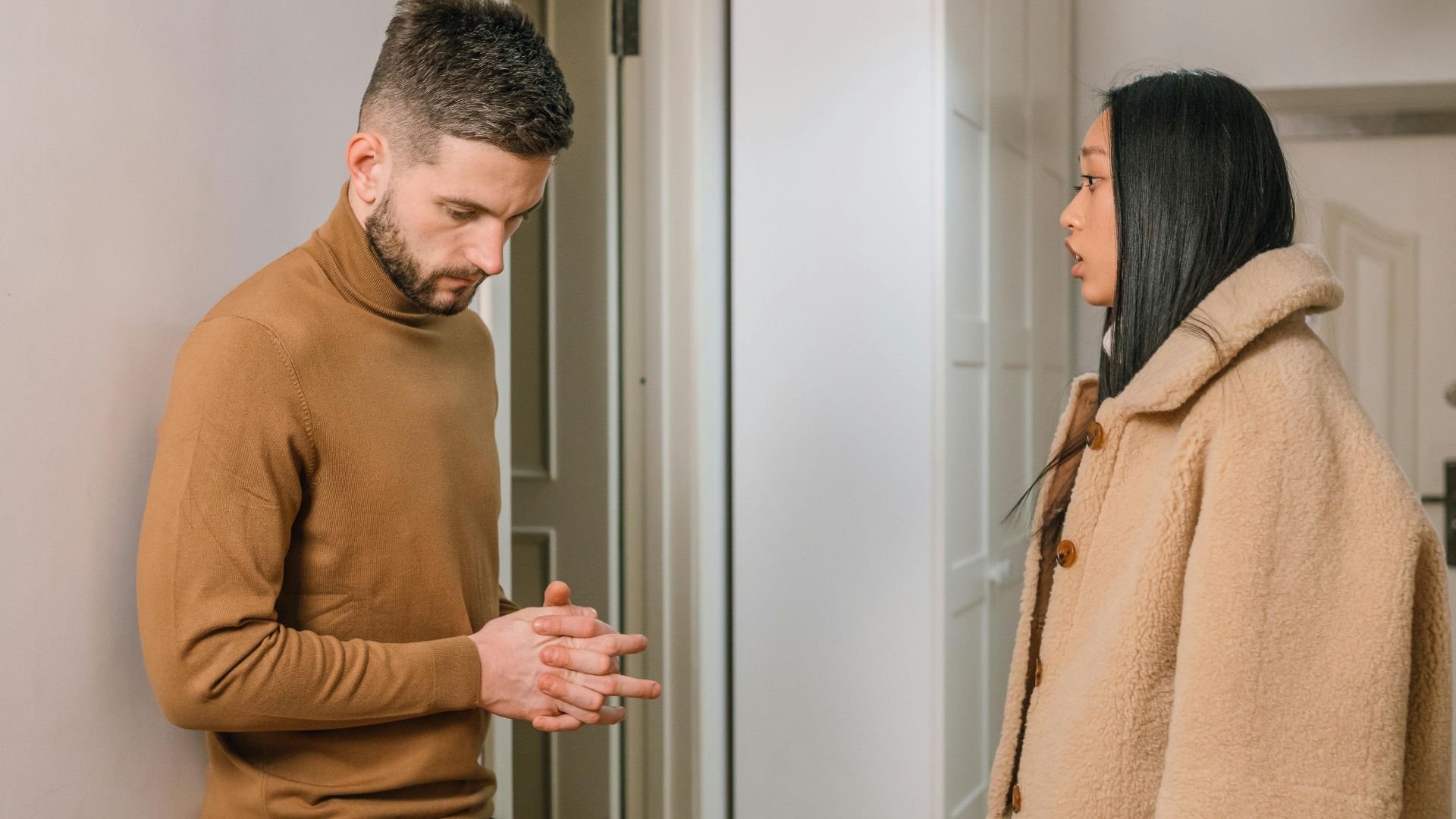 A man and woman having a serious discussion indoors, portraying relationship tension.