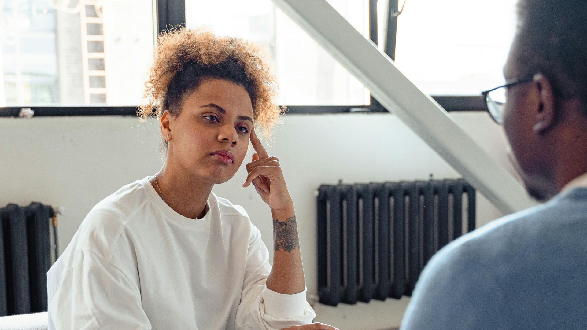 African American couple engaged in a serious conversation indoors, reflecting on relationship challenges.