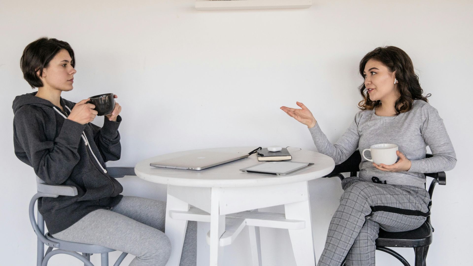 Two women enjoying a casual conversation with coffee in a cozy indoor setting, enhancing connections.