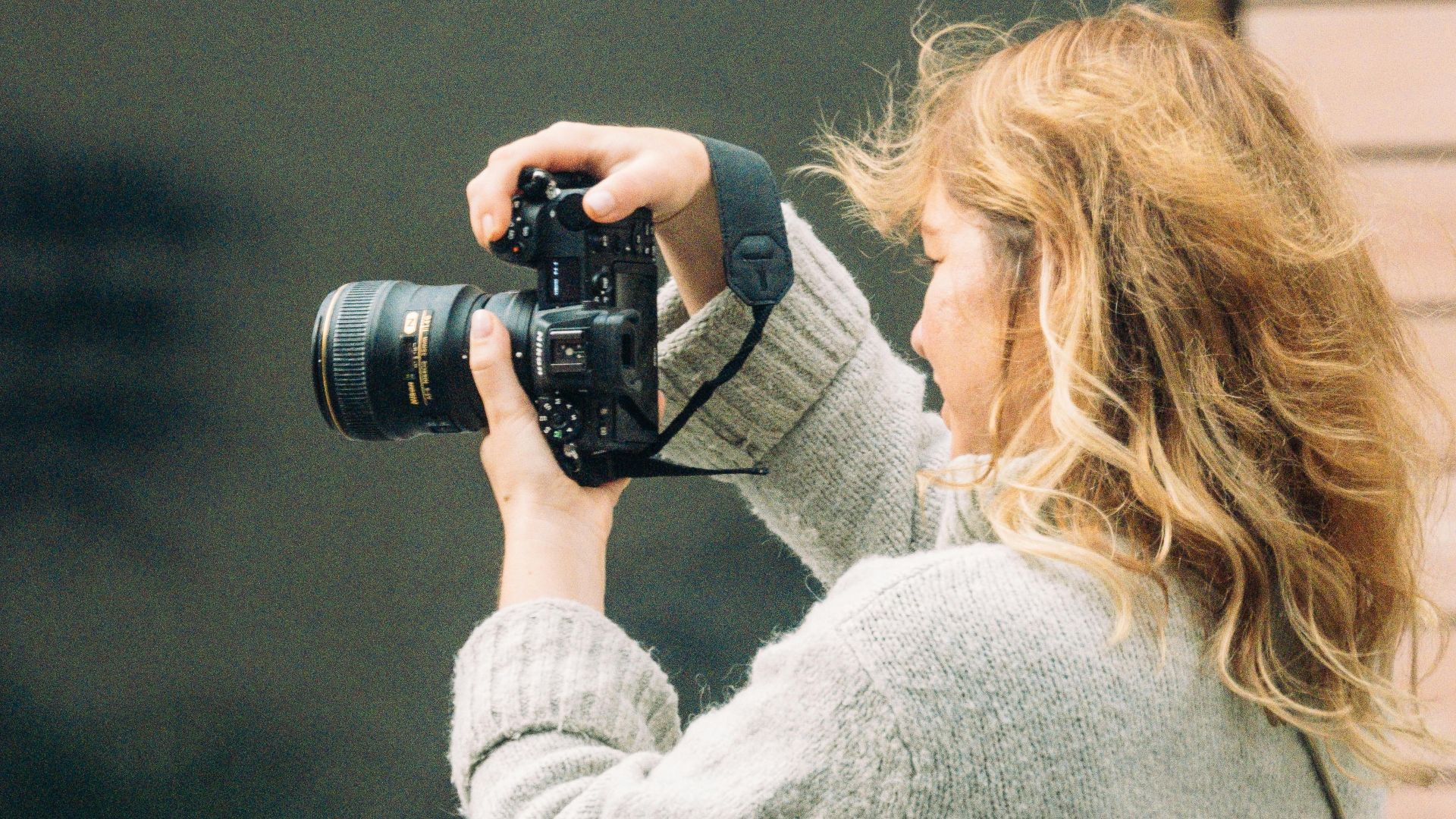 A woman photographer takes pictures outdoors in Frankfurt, capturing dynamic urban life.